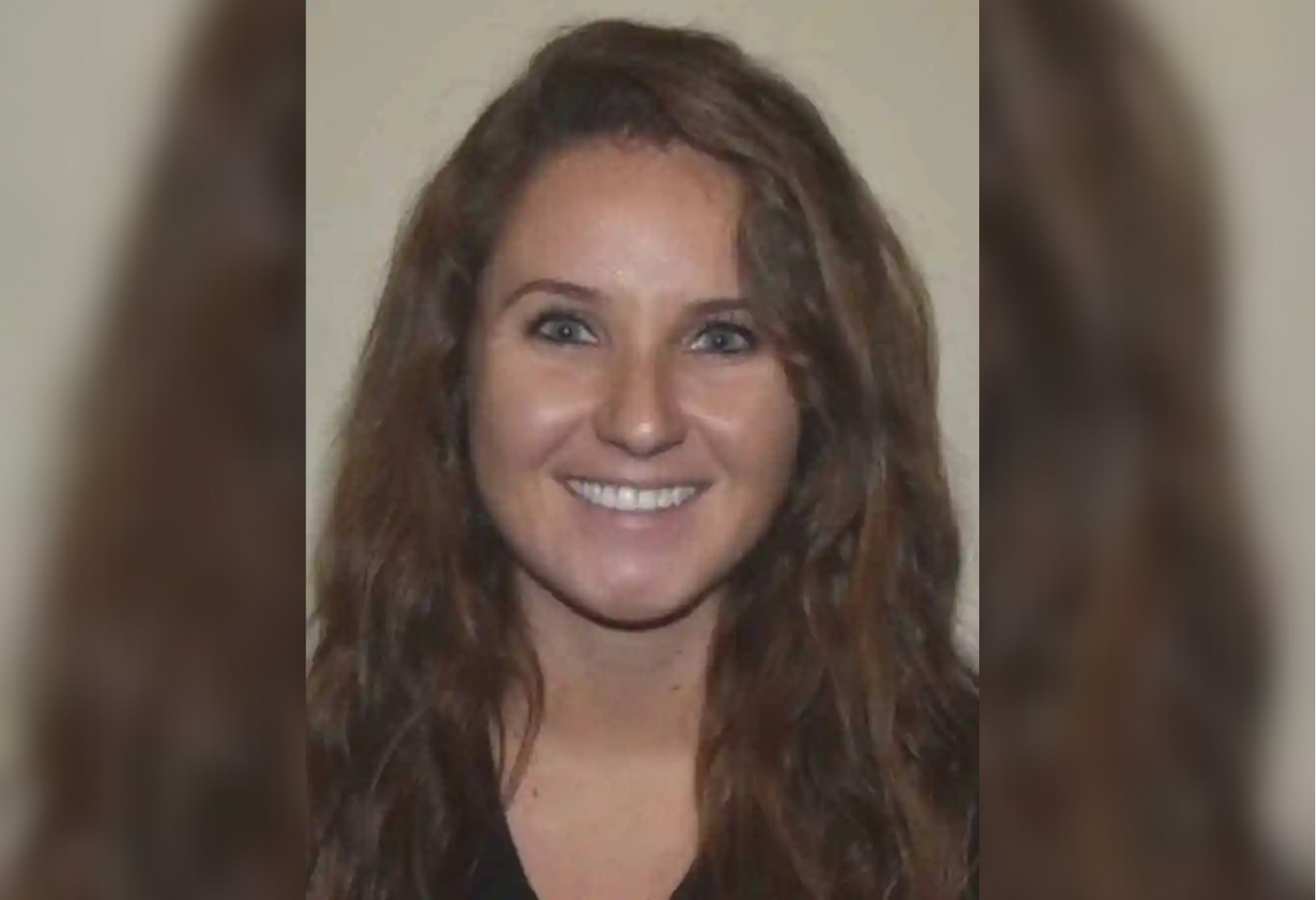 Portrait of Sipsey Krout. A woman with long wavy brown hair smiles broadly against a neutral background. Her expression is friendly and warm, conveying a positive and inviting tone.
