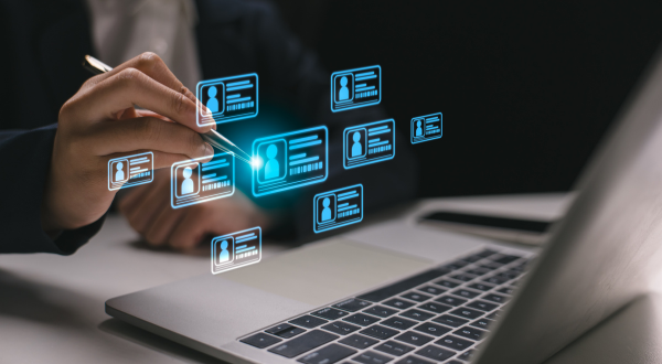 Businessman selecting digital profile on virtual screen using laptop, representing identity verification, user data management, and digital transformation in business and HR technology.