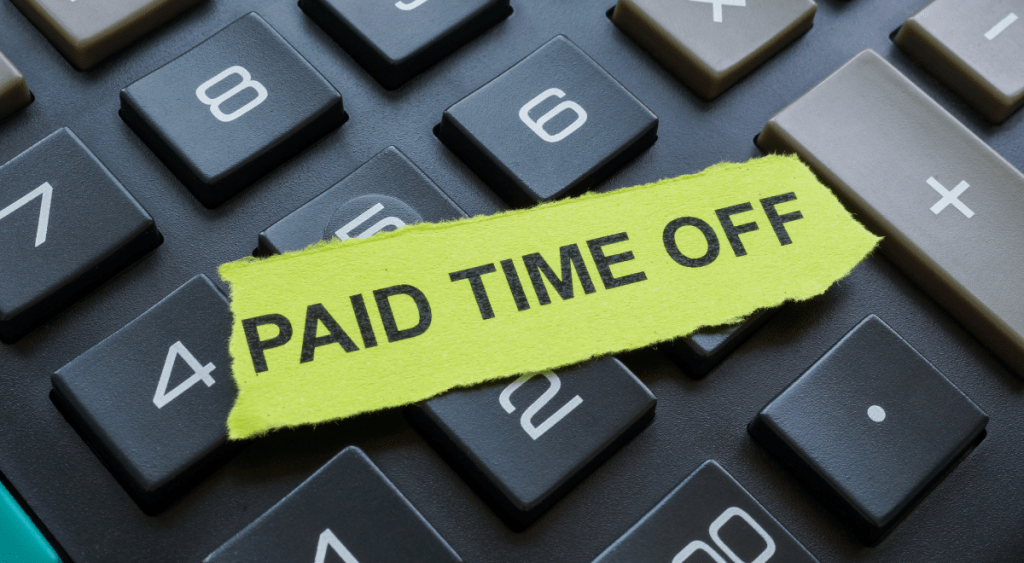 keyboard with a sticky note that says Paid Time Off lying atop of it
